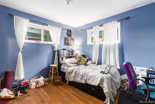 a bedroom with a bed and windows