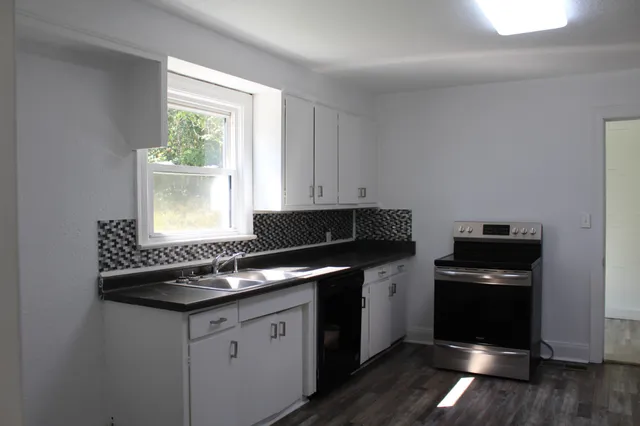 a kitchen with granite countertop a stove and a refrigerator