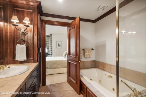 a bathroom with a tub sink and mirror
