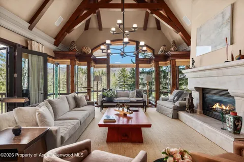 a living room with patio fireplace furniture and a large window