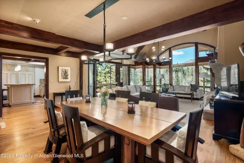 a dining room with wooden floor a chandelier a wooden table and chairs