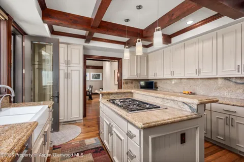 a kitchen that has a sink a stove and a refrigerator