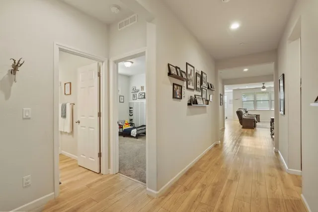 a view of a hallway with wooden floor windows and a livingroom