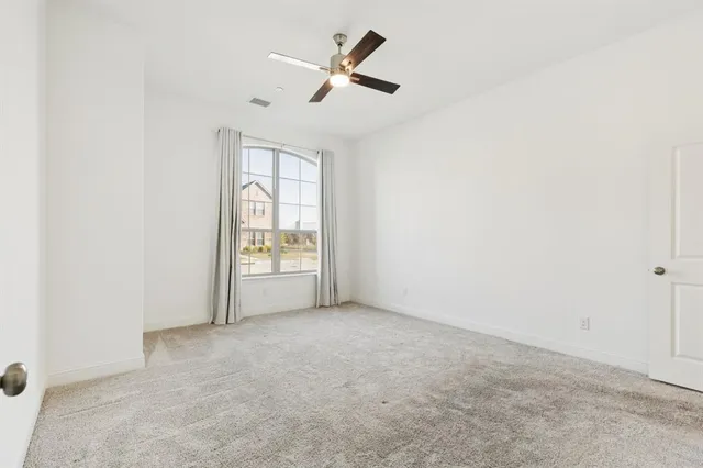 an empty room with fan and windows