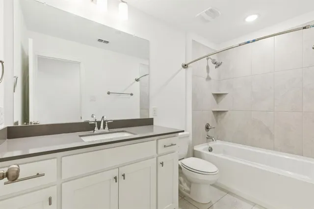 a bathroom with a granite countertop sink a toilet and a bathtub
