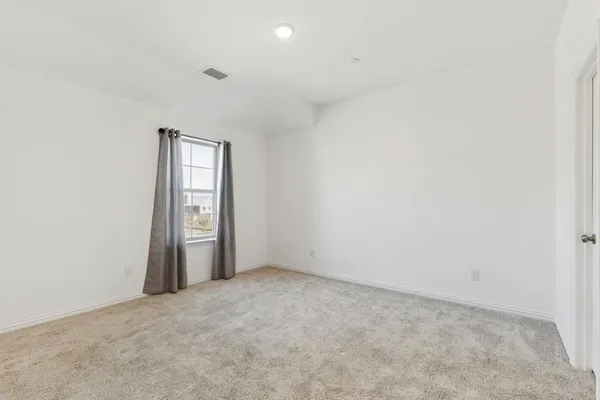 an empty room with windows and closet