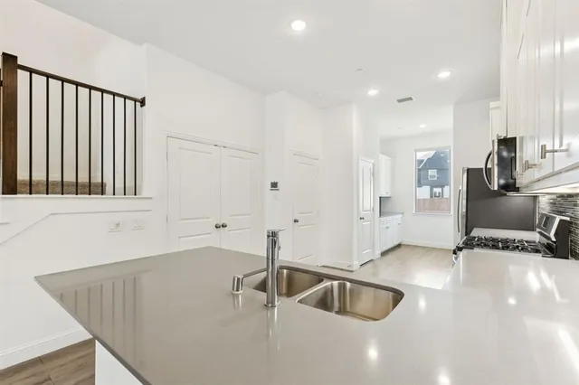 a kitchen with granite countertop a sink and stainless steel appliances