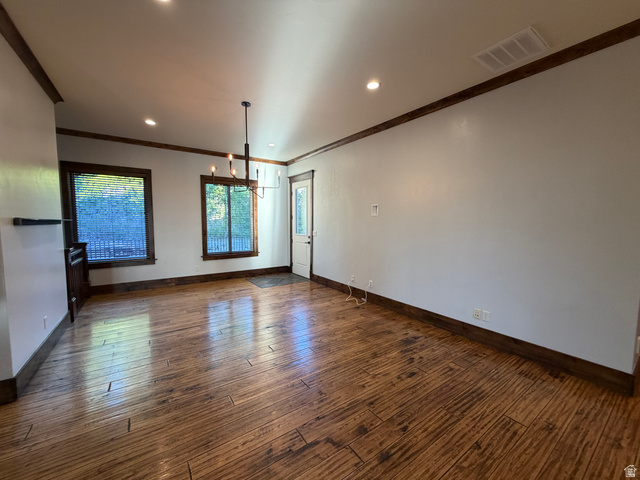 4536 North 475 East Provo, UT 84604 - Photo 5 of 65 Expansive living area with wood-finish flooring, two large windows, a ceiling-mounted chandelier, recessed lighting, and a white entry door