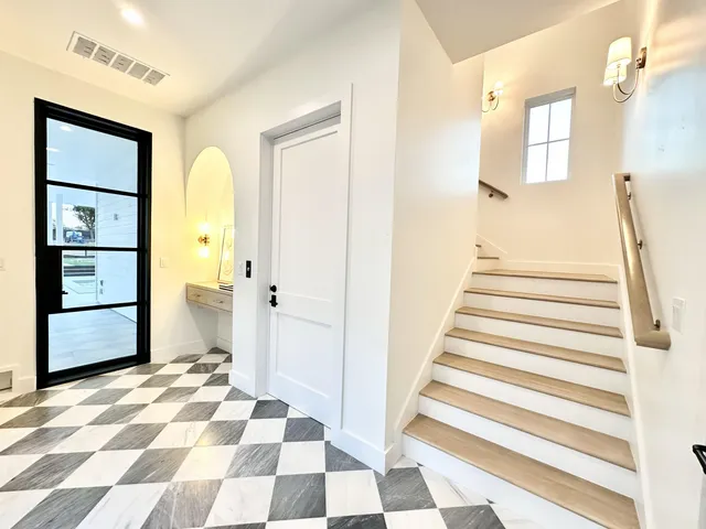 a view of a bedroom with wooden floor and white walls