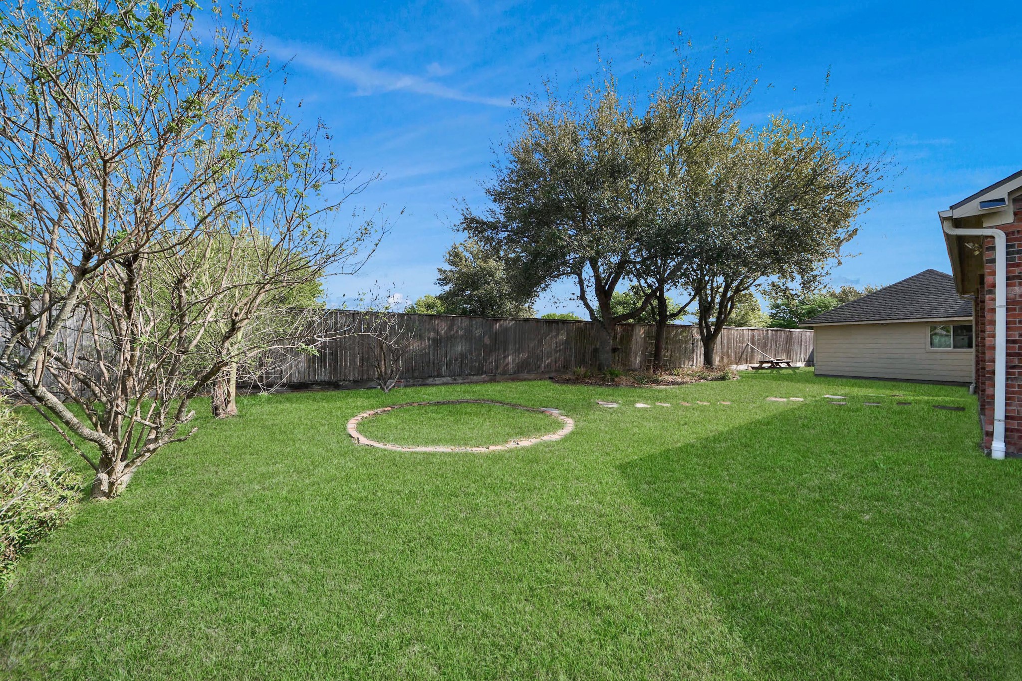 17618 Raven Canyon Lane Houston, TX 77095 - Photo 39 of 45 Another angle of the backyard with a clear view of the lush lawn, trees, and neatly maintained landscaping.