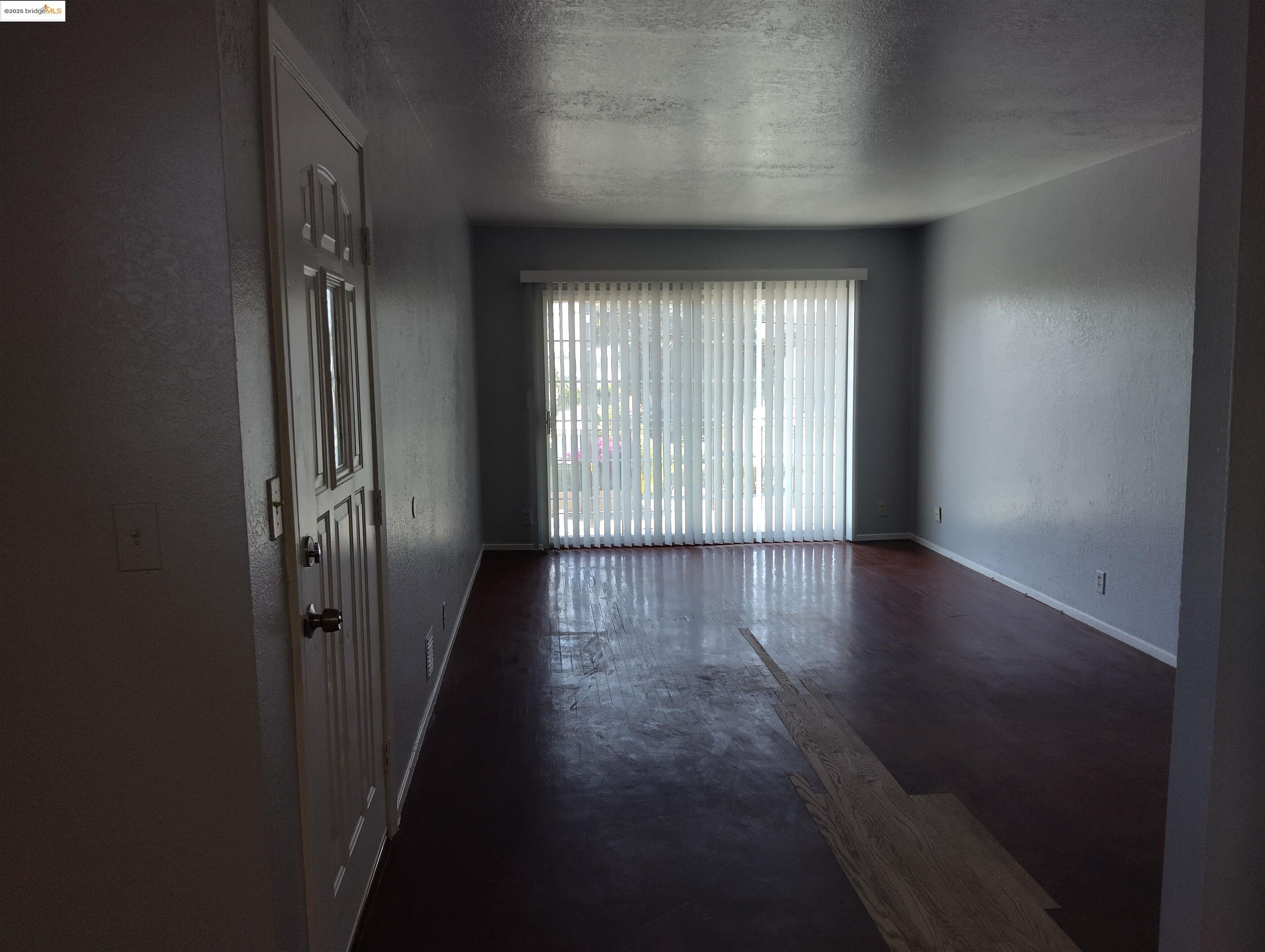 1109 Seminary Avenue Oakland, CA 94621 - Photo 37 of 51 an empty room with wooden floor and windows