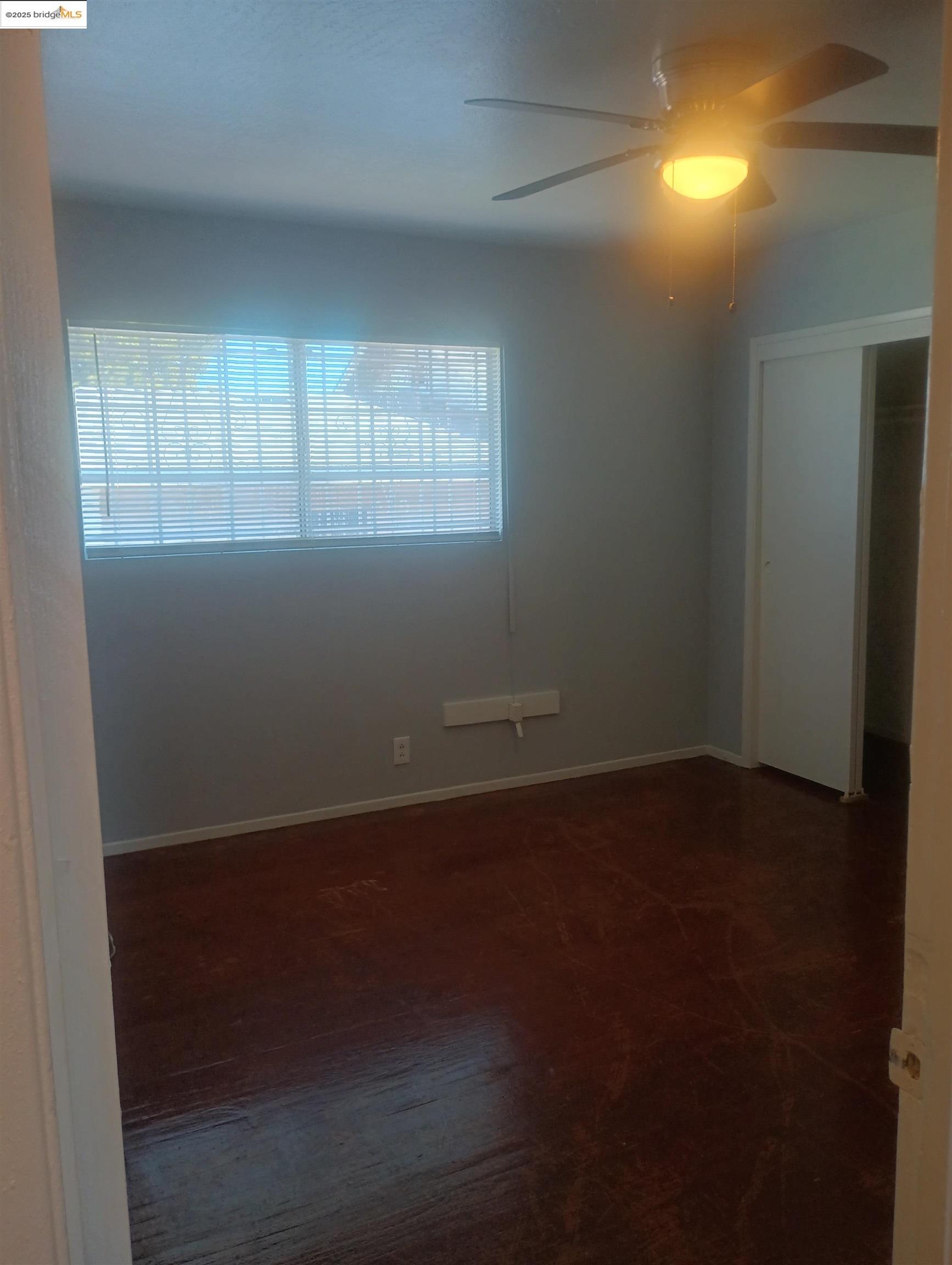 1109 Seminary Avenue Oakland, CA 94621 - Photo 10 of 51 an empty room with wooden floor and windows