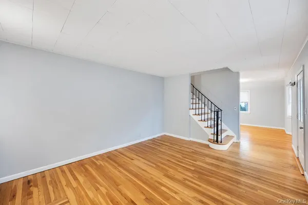 a big room with wooden floor and bathroom view