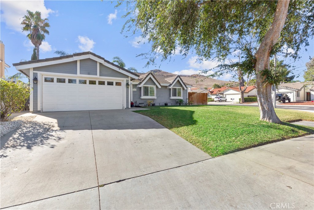 a front view of a house with a yard and trees