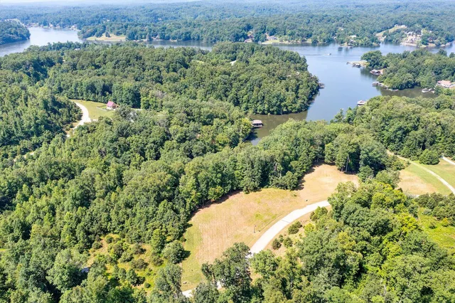 an aerial view of a house with a yard and lake view