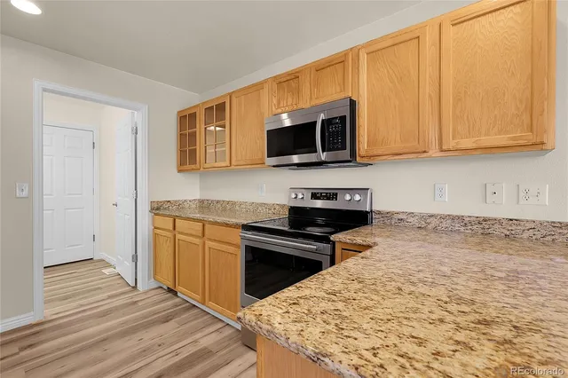 a kitchen with stainless steel appliances granite countertop a sink and dishwasher with wooden floor
