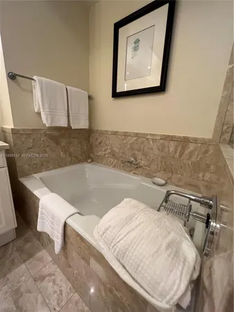 a bedroom with bed and a flat tv screen on dresser
