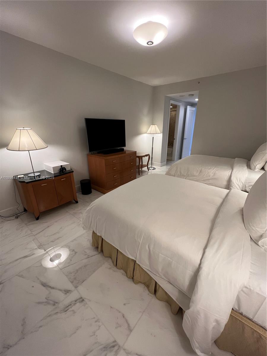 1435 Brickell Avenue, Unit 3307 Miami, FL 33131 - Photo 35 of 77 a bedroom with bed and a flat tv screen on dresser