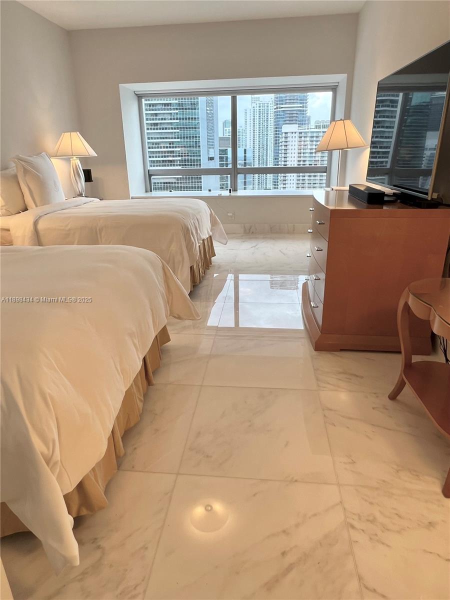 1435 Brickell Avenue, Unit 3307 Miami, FL 33131 - Photo 42 of 77 a spacious bedroom with a bed a couch and large window