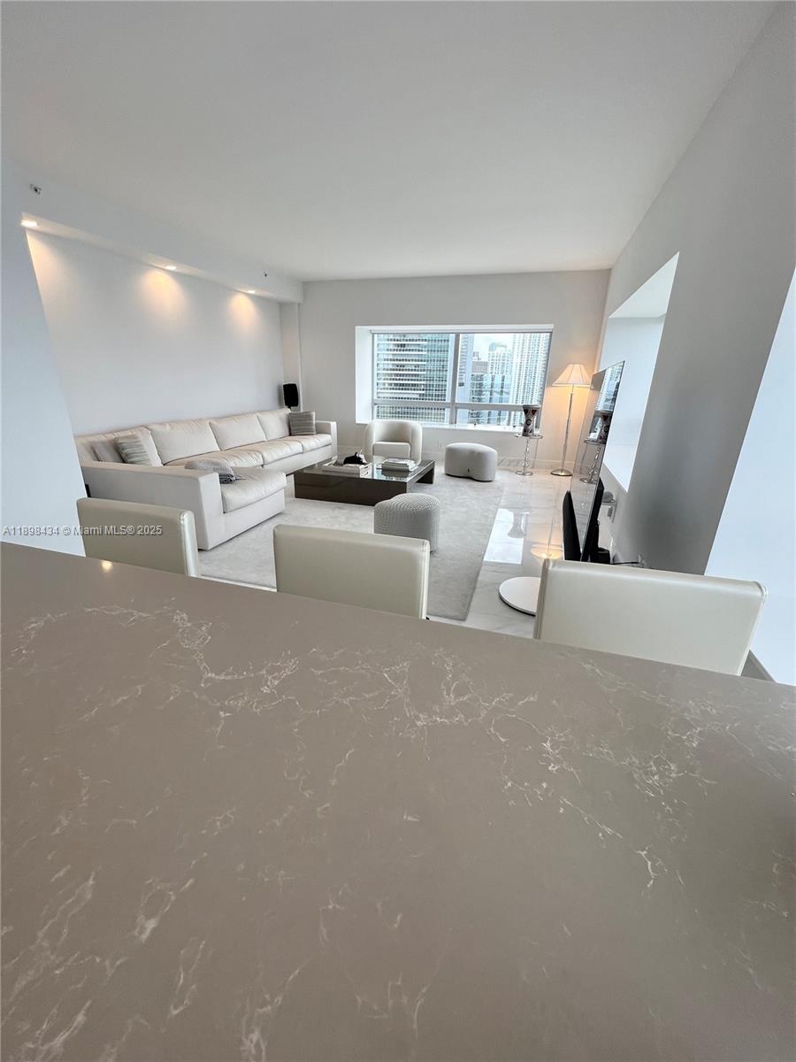 1435 Brickell Avenue, Unit 3307 Miami, FL 33131 - Photo 56 of 77 a living room with couches and a large mirror with wooden floor