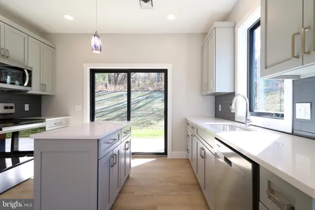 a kitchen with stainless steel appliances granite countertop a sink a stove and a refrigerator