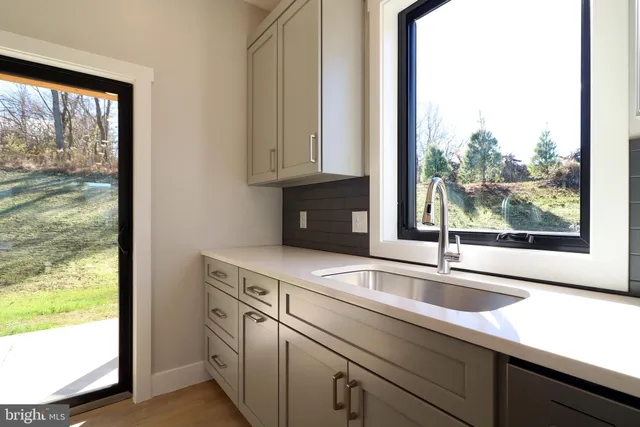 a view of a kitchen with a sink and large window