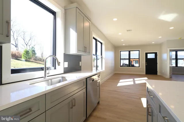 a kitchen with stainless steel appliances granite countertop a refrigerator a stove and a sink