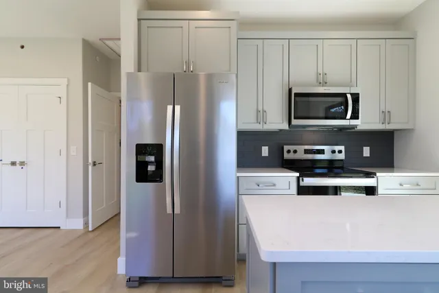 an empty room with large windows and wooden floor