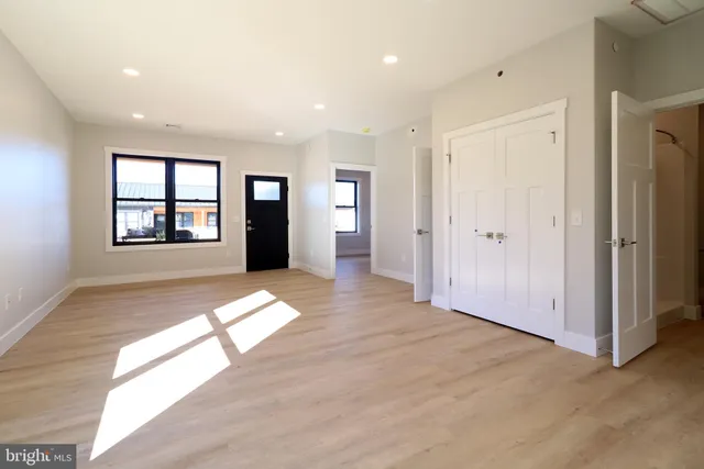 an empty room with wooden floor and windows