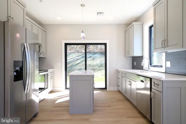 a kitchen with stainless steel appliances granite countertop a refrigerator and a stove top oven