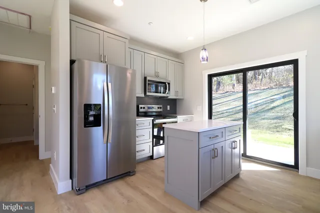 a kitchen with stainless steel appliances a stove a microwave and a cabinets