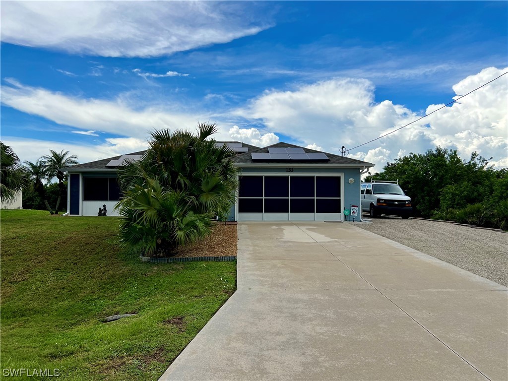 153 Patio Street Lehigh Acres, FL 33974 - Photo 1 of 27 front view of a house with a yard
