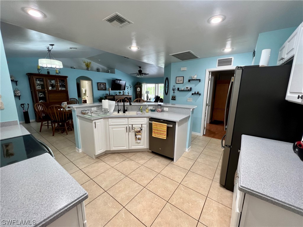153 Patio Street Lehigh Acres, FL 33974 - Photo 16 of 27 a kitchen with stainless steel appliances granite countertop a sink stove and refrigerator