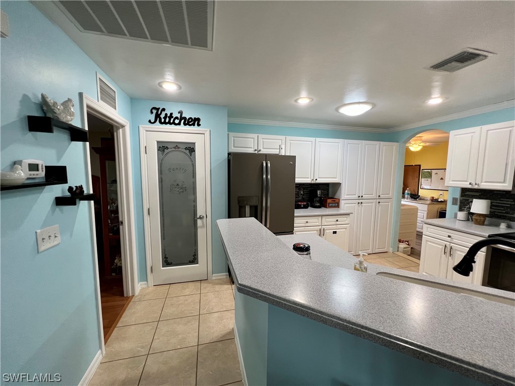 153 Patio Street Lehigh Acres, FL 33974 - Photo 17 of 27 a kitchen with stainless steel appliances a refrigerator sink and microwave