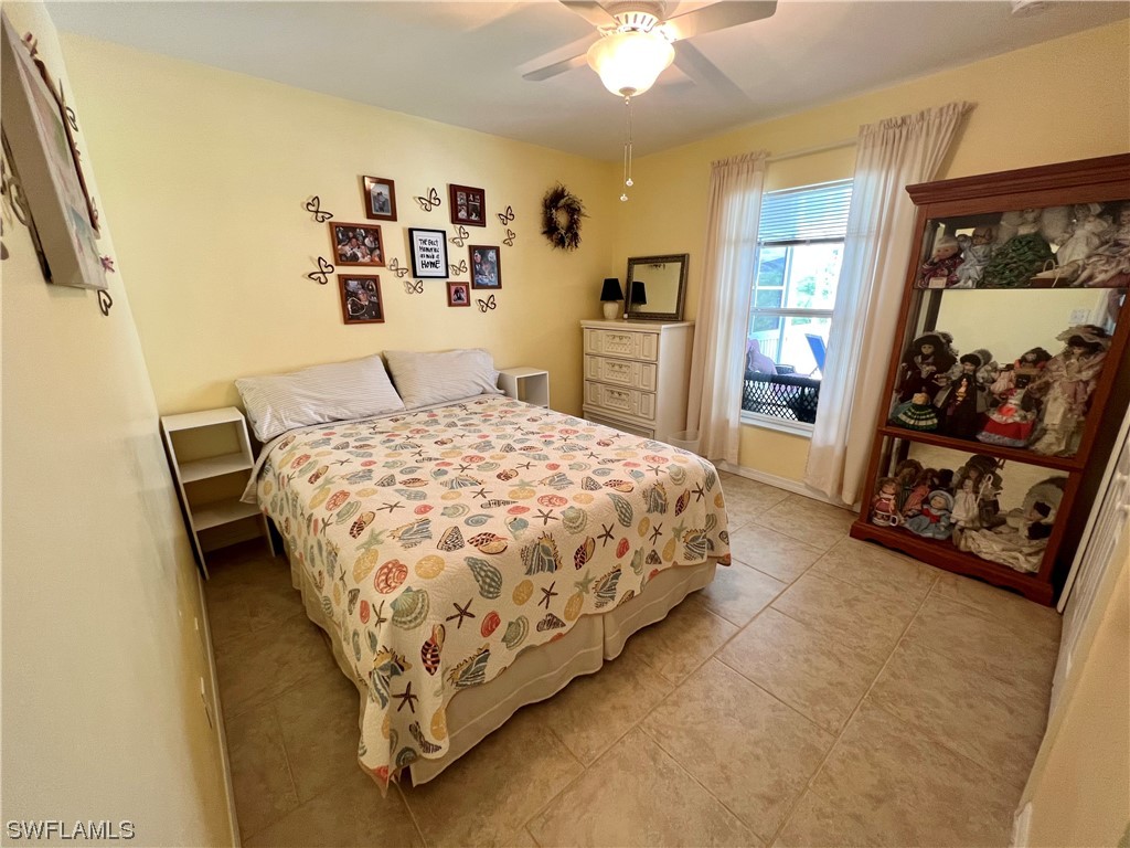 153 Patio Street Lehigh Acres, FL 33974 - Photo 25 of 27 a bed sitting in a bedroom next to a window