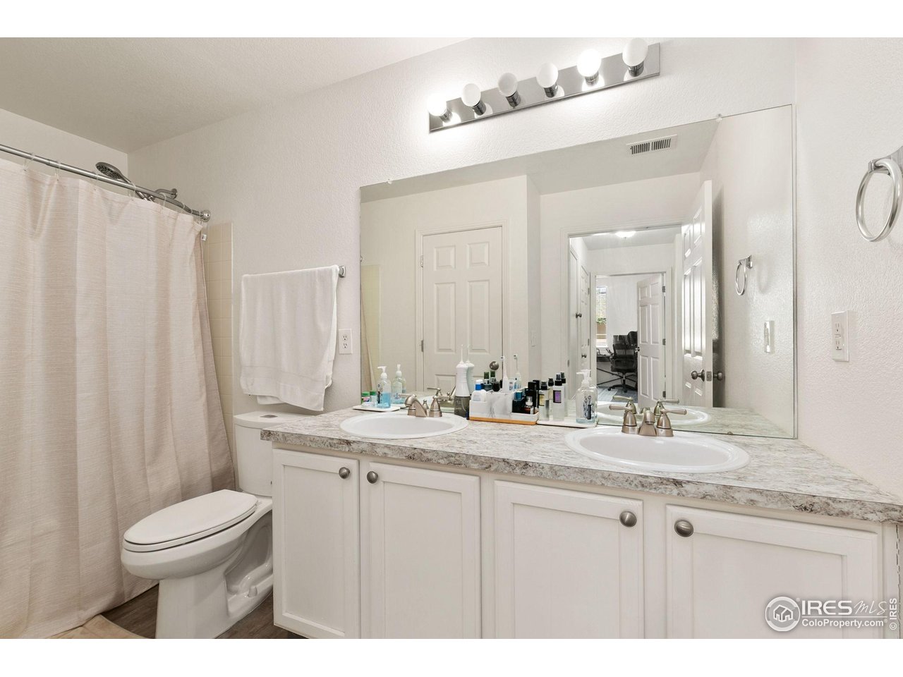 3002 West Elizabeth Street, Unit 1C Fort Collins, CO 80521 - Photo 7 of 15 a bathroom with a granite countertop sink a toilet and a mirror