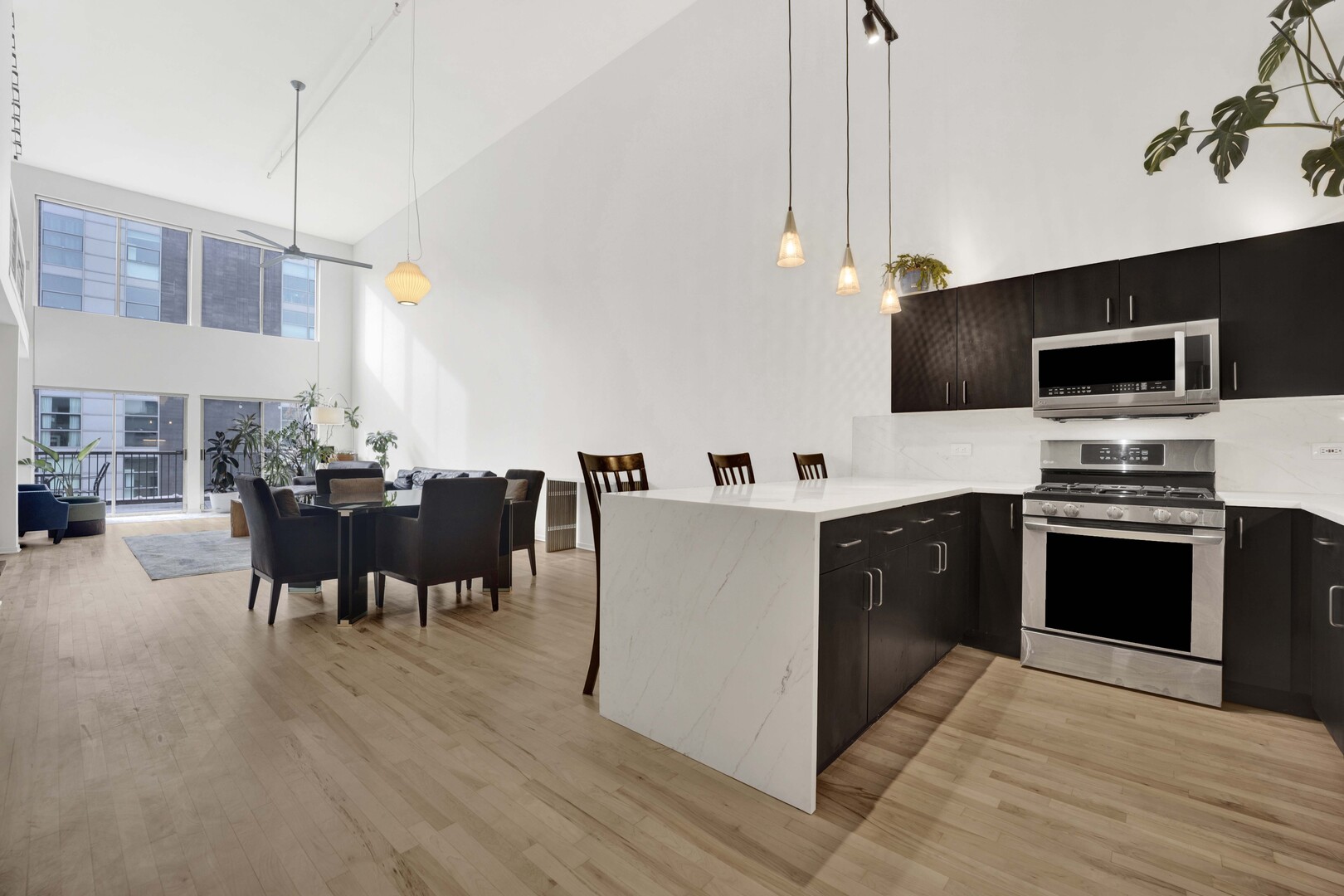203 South Sangamon Street, Unit 310 Chicago, IL 60607 - Photo 3 of 34 a large kitchen with kitchen island a sink table and chairs