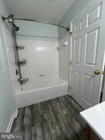 a bathroom with a tub a sink and a shower