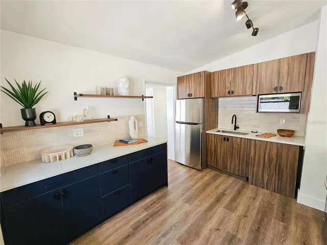 a kitchen with a sink a refrigerator and cabinets