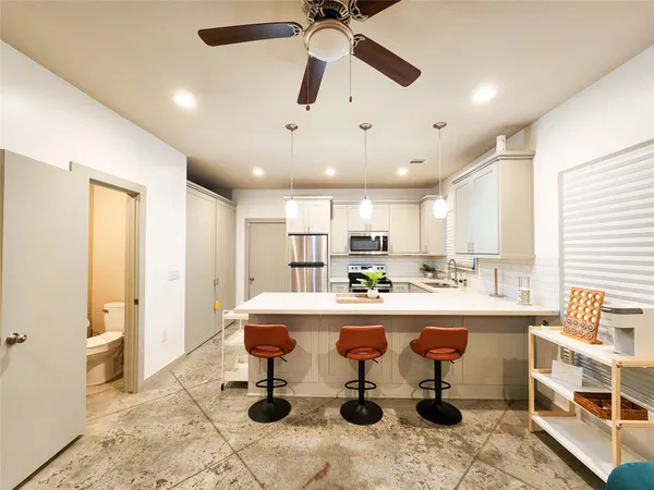 a living room with stainless steel appliances kitchen island granite countertop furniture and a dining table