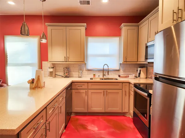 a kitchen with stainless steel appliances a sink cabinets and a refrigerator