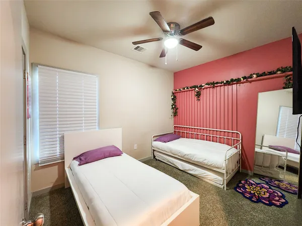 a bedroom with two beds and a chandelier