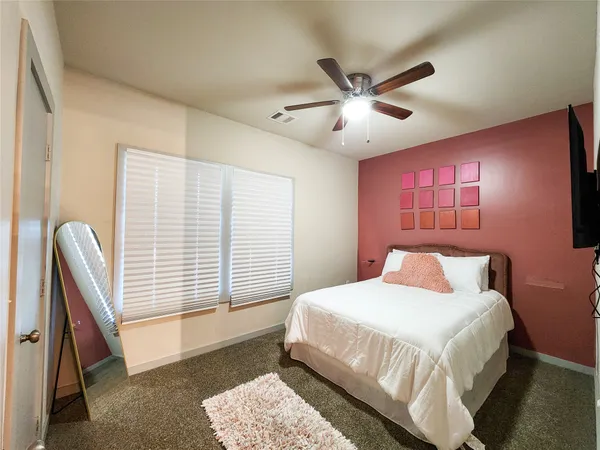 a bedroom with a large bed and a chandelier