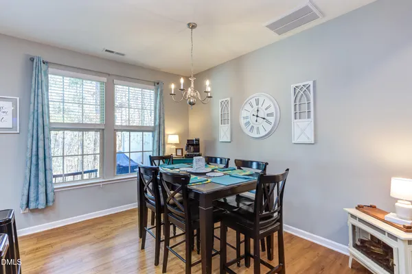 a view of a dining room with furniture a chandelier and wooden floor