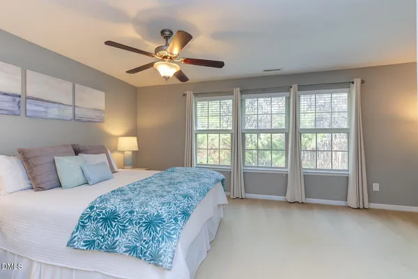 a spacious bedroom with a large bed and a chandelier
