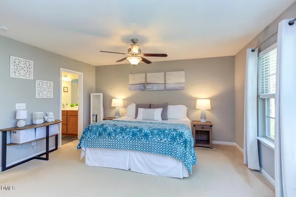 a bedroom with a bed chandelier and a window