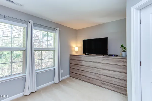 a room with flat screen tv cabinets and a bed