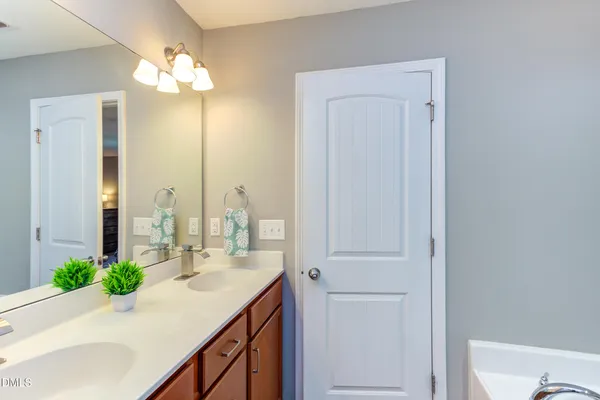 a bathroom with a sink vanity granite and a mirror