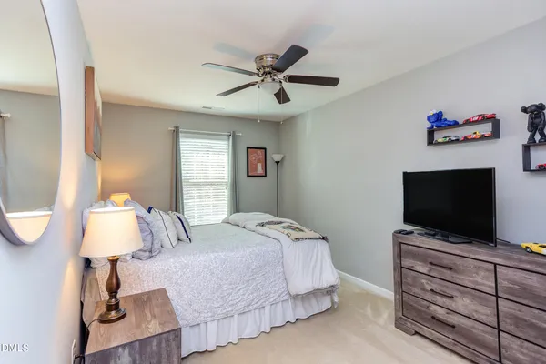 a bedroom with a bed flat screen tv and a chandelier