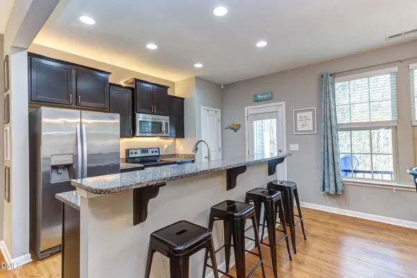 a kitchen with stainless steel appliances granite countertop sink cabinets and wooden floor